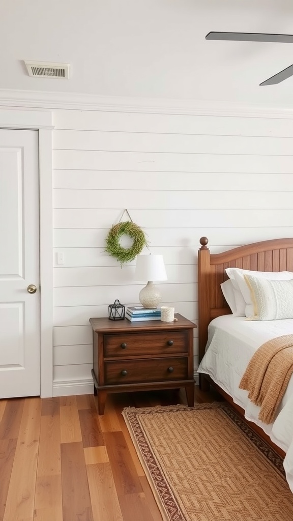 A cozy farmhouse bedroom featuring a shiplap accent wall, wooden furniture, and simple decorative elements.