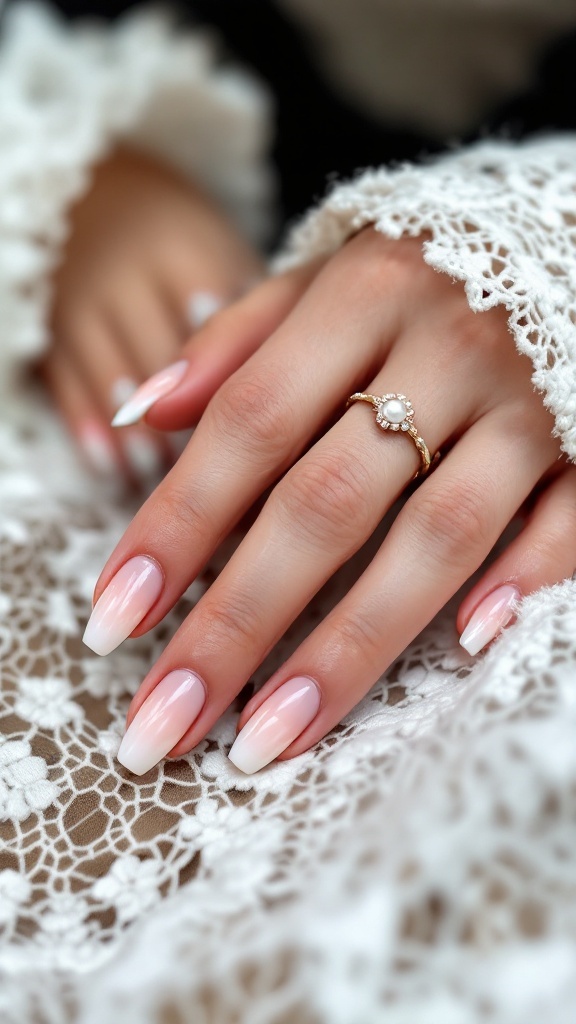 Close-up of elegant ombre nails featuring pearl detailing, with a lace background.