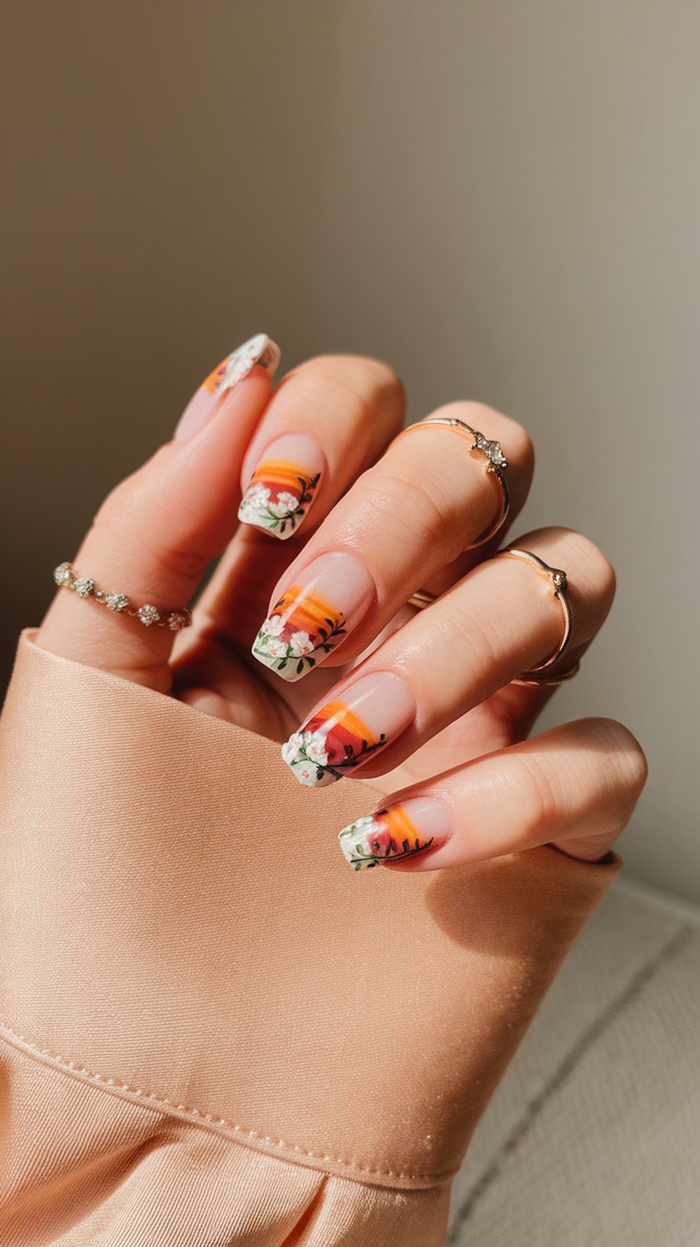 Nails painted with sunset colors and floral accents
