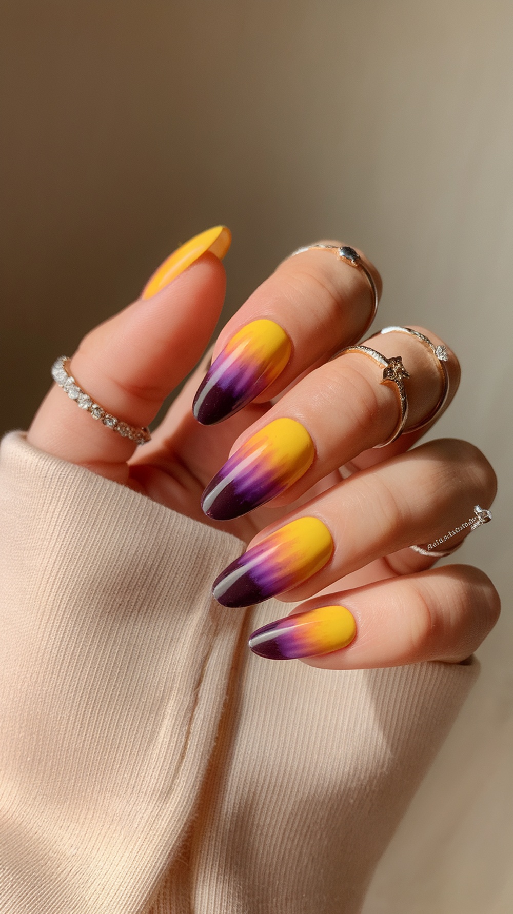 Nails featuring a sunset ombre effect with yellow and purple colors.