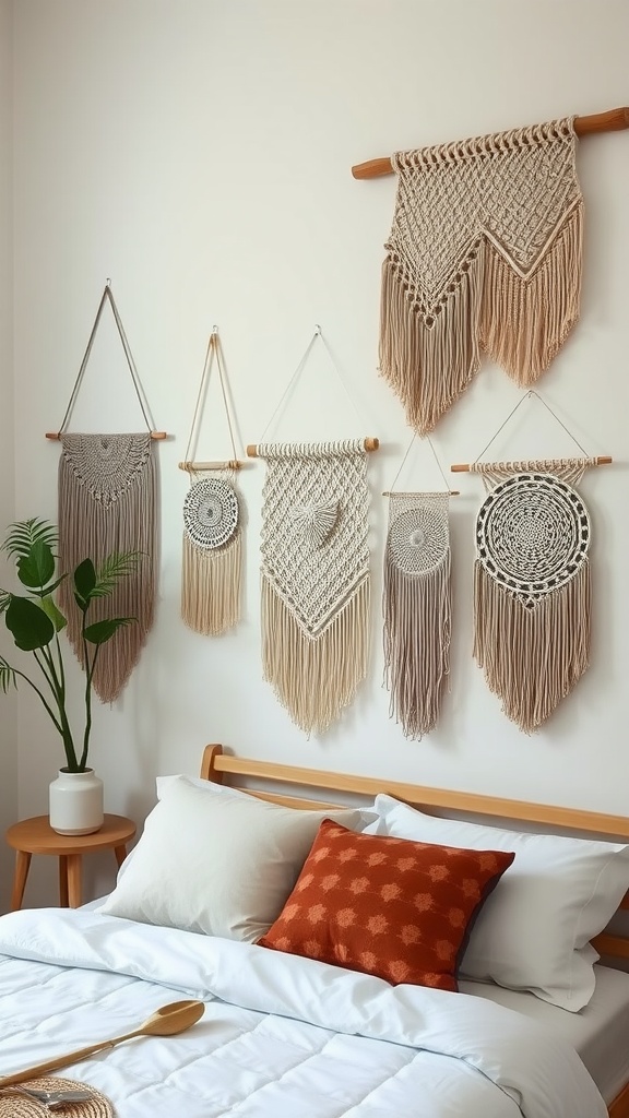A collection of macramé wall hangings in soft neutral tones, displayed above a bed with white bedding and an orange patterned pillow.