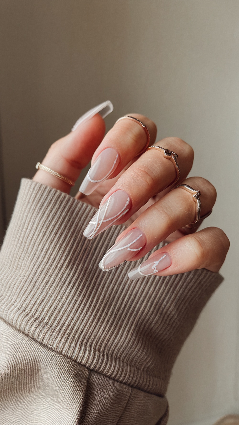 A close-up of slim, beautifully manicured nails with delicate designs.
