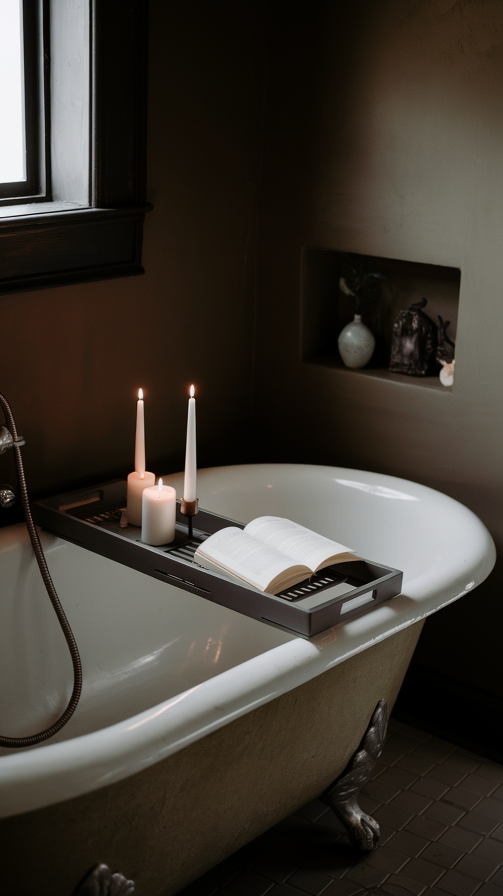 A classic bathtub tray with candles and an open book on a clawfoot tub.