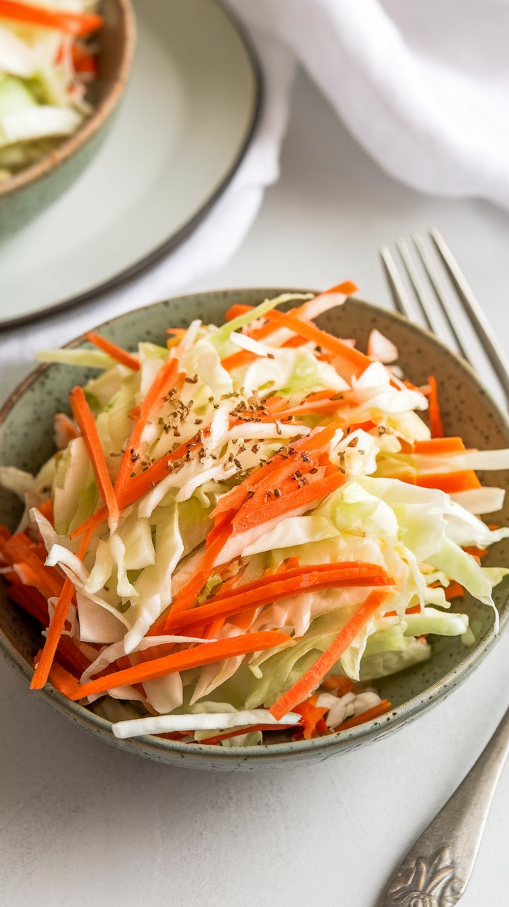 Cabbage and carrot slaw in a bowl with apple cider dressing