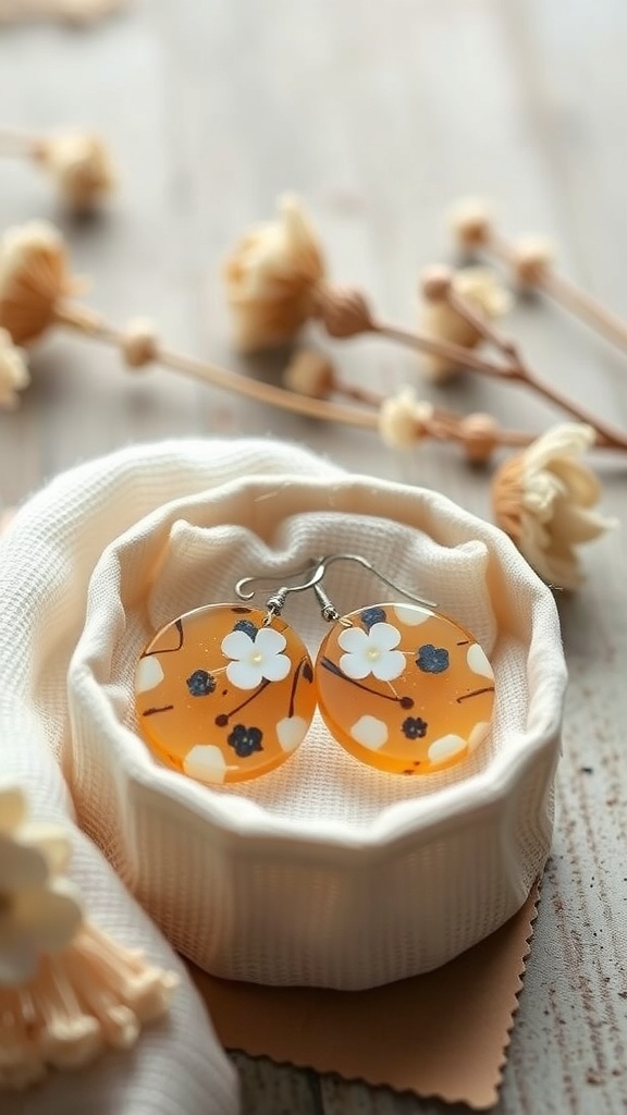 Pendientes de resina en tonos suaves con flores, presentados en una caja suave.