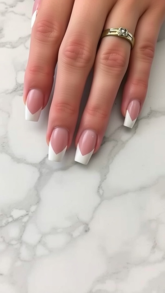 A hand with elegant blush pink nails holding a bouquet of white roses.