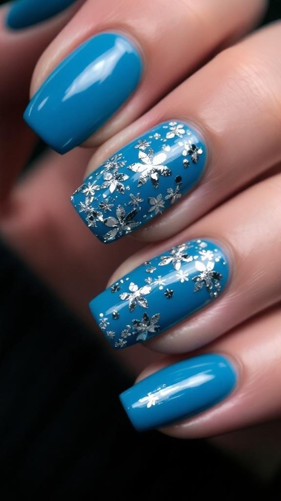 Nails painted in cerulean blue with a silver foil accent nail.