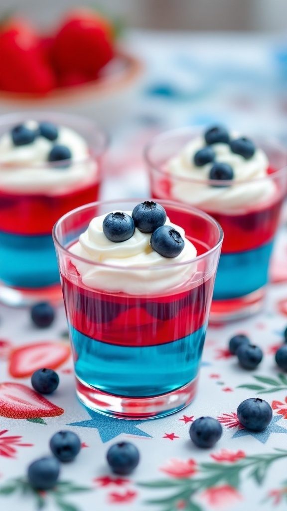 Star-Spangled Jello Parfaits with layers of red and blue jello topped with whipped cream and berries.