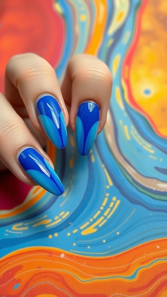 Close-up of royal blue acrylic nails with abstract designs in lighter blues and orange