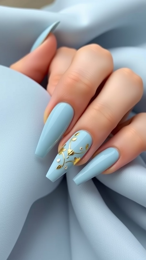 Close-up of baby blue acrylic nails with gold foil accents and a subtle design
