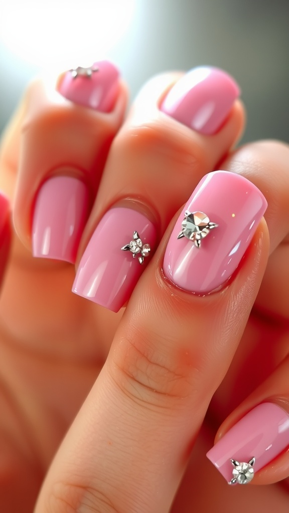 Close-up of baby pink chrome nails with rhinestone details
