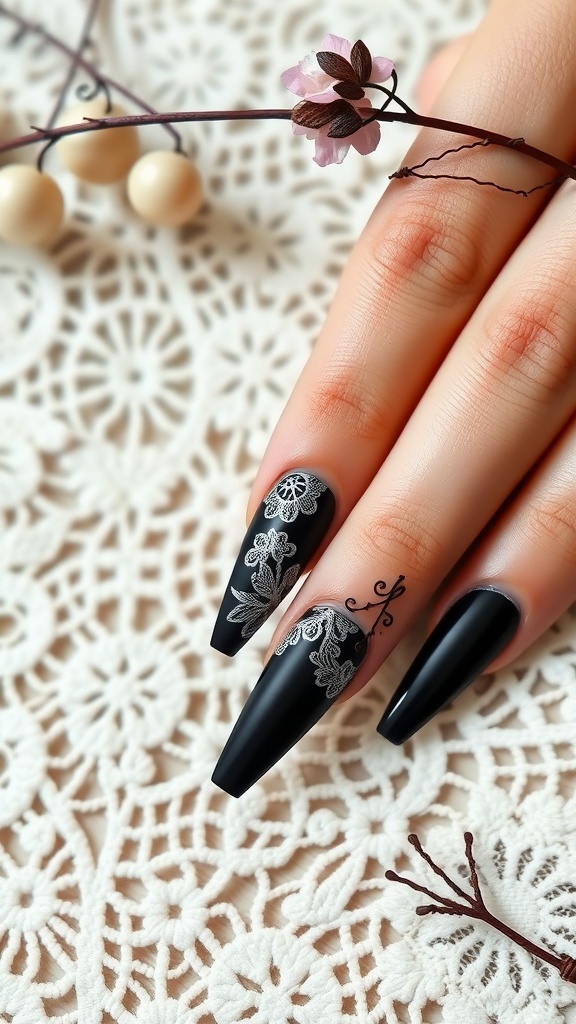 A close-up of black acrylic nails featuring intricate white lace inlays on a delicate lace background