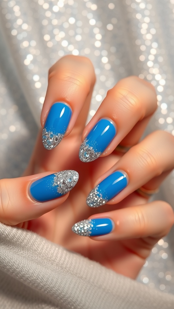 Close-up of blue nails with silver glitter fade tips