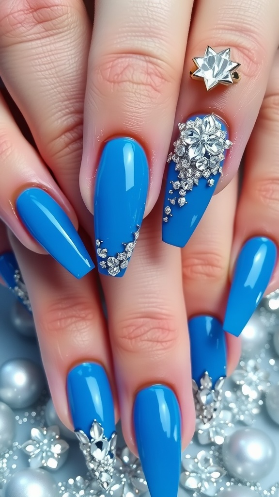 A close-up of long blue nails with silver metallic accents and embellishments.