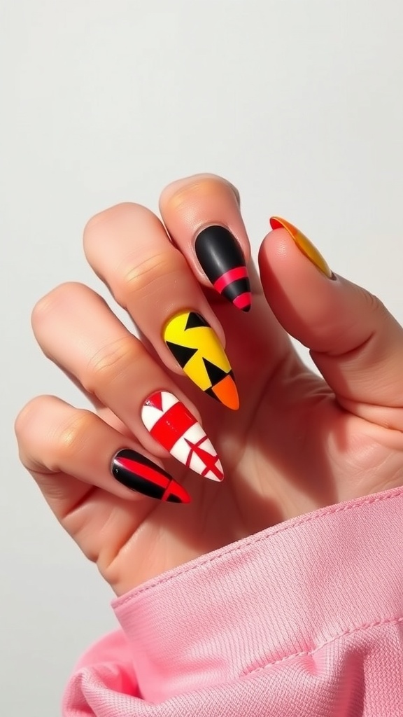 A hand with stiletto nails featuring bold geometric patterns in black, red, yellow, and white.