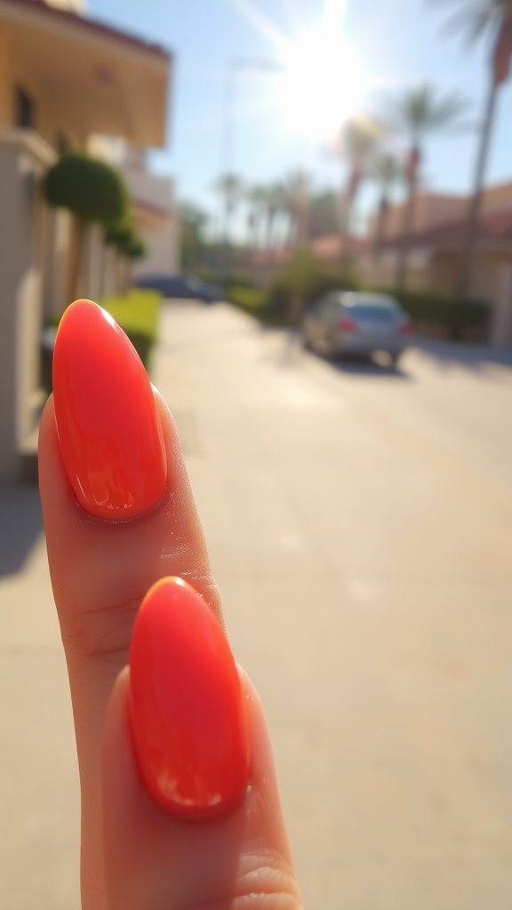 Close-up of bright coral almond-shaped nails in sunlight