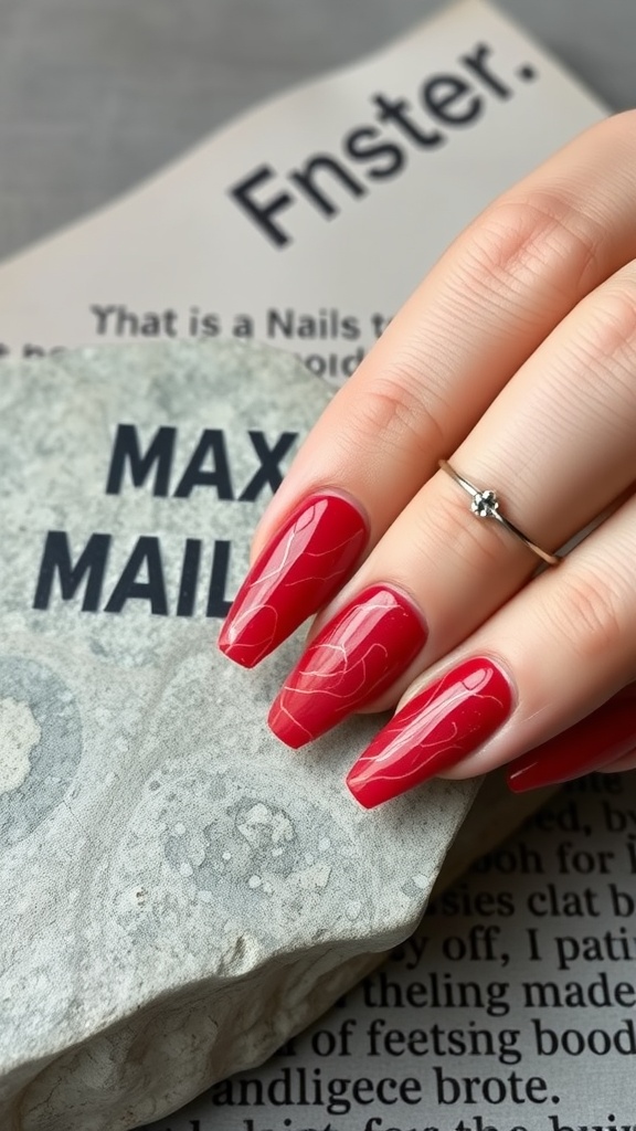 Close-up of red marble nails resting on a stone surface with minimalistic decor.