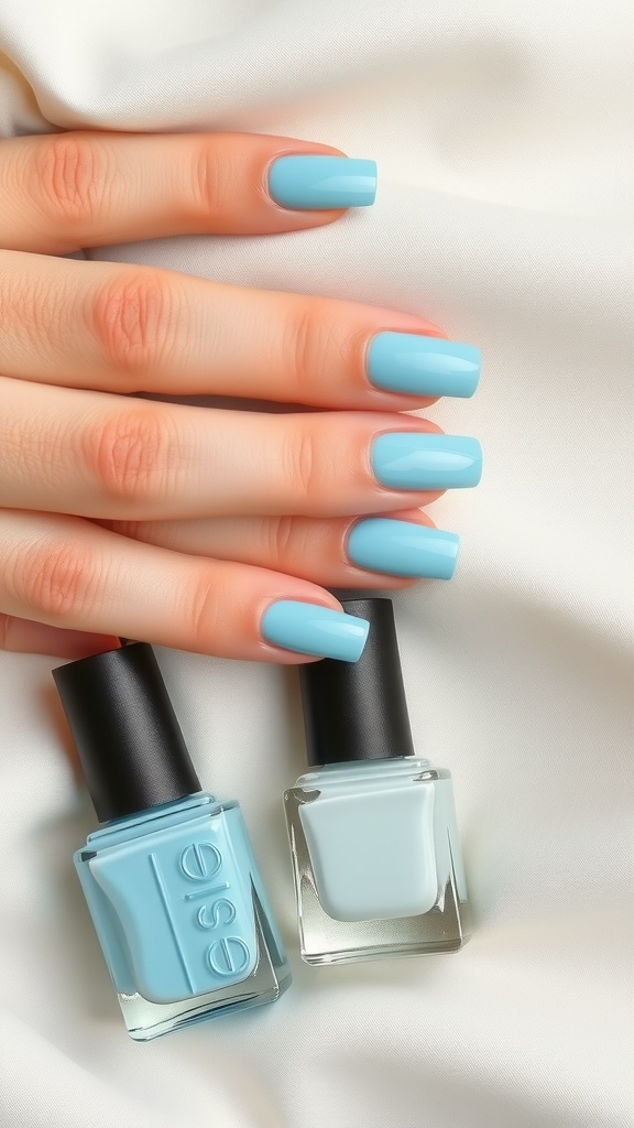 Light blue almond nails with two nail polish bottles on a white satin fabric.