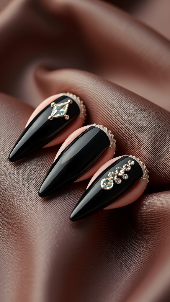 Close-up of black coffin-shaped nails with rhinestone details on a soft fabric background.