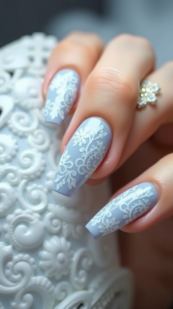 Close-up of light blue nails with intricate white lace designs.