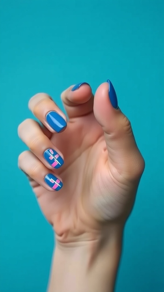 A hand showing off electric blue nails with geometric patterns in pink and white.