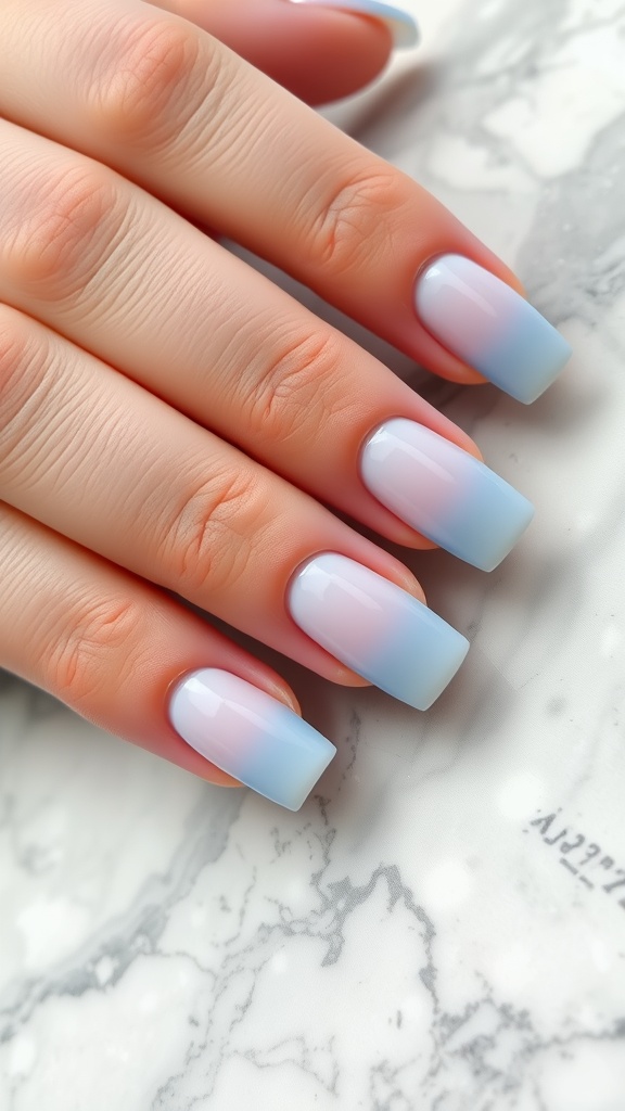 Light blue ombre French tip nails on a marble surface