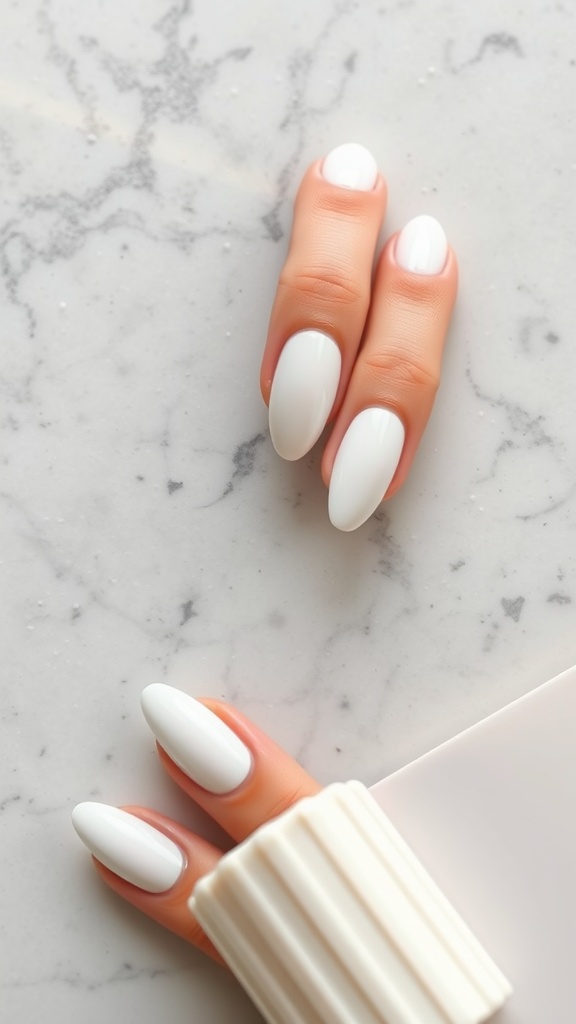 Two hands with white almond-shaped nails on a marble surface