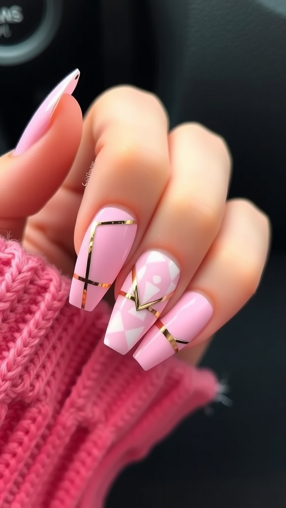 Close-up of light pink chrome nails with geometric patterns and gold accents.