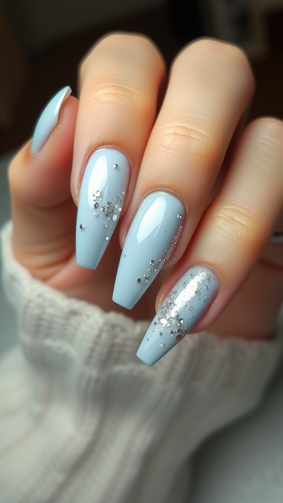 A close-up of light blue chrome nails accented with glitter.