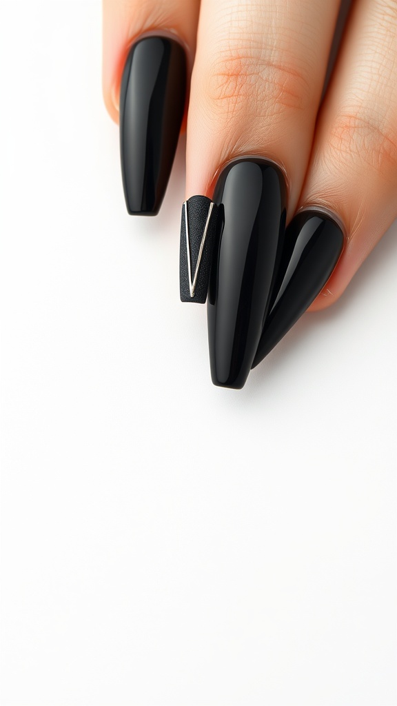 Coffin-shaped glossy black nails with a metallic accent