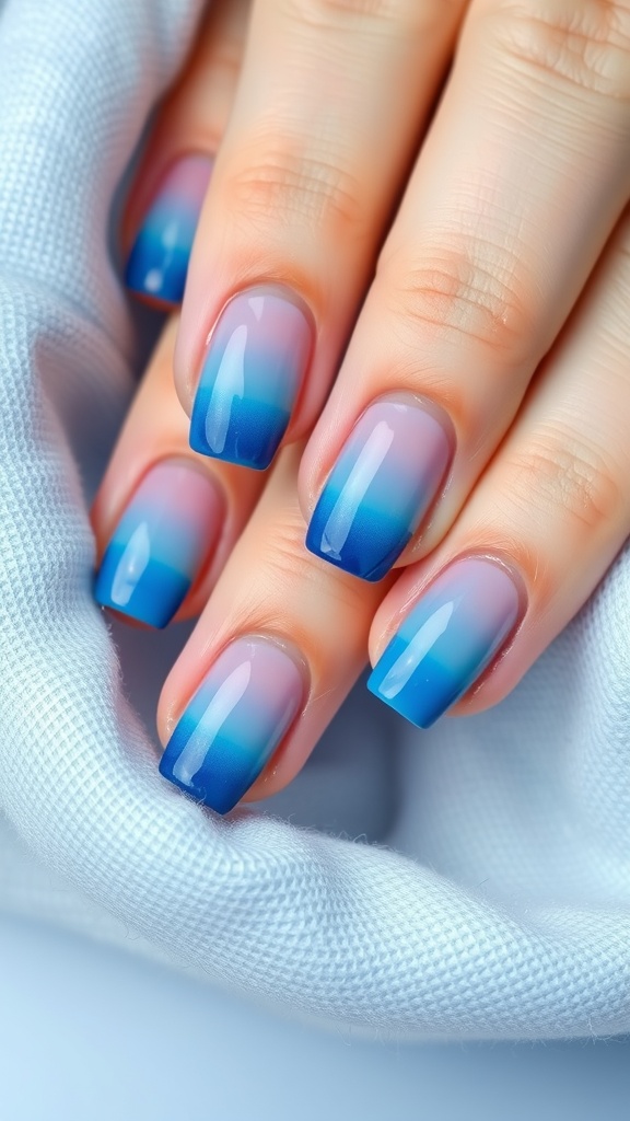 Nails with gradient blue ombre design, showcasing a blend of pastel and deep blue shades.