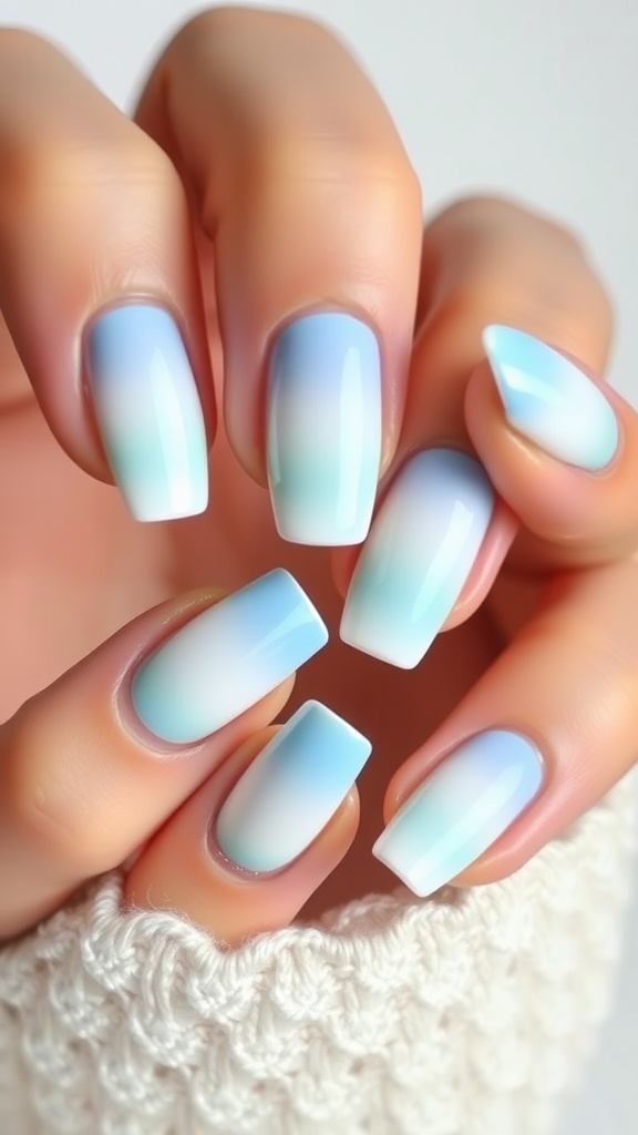 Close-up of hands with light blue chrome gradient nails on a white knitted background.