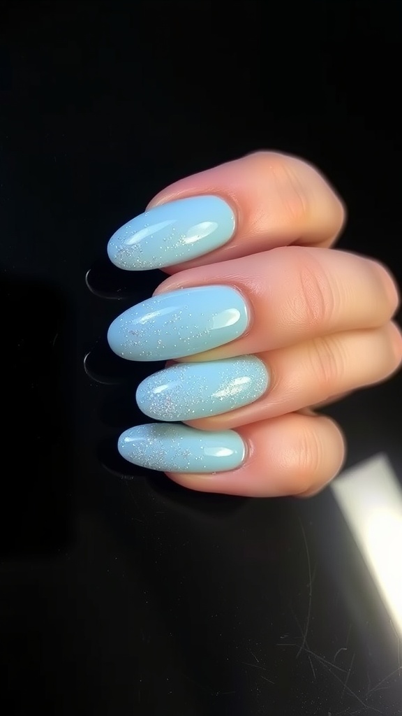 Light blue almond-shaped nails with glitter accents