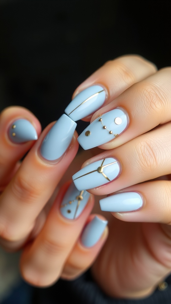 A close-up of light blue nails adorned with gold accents, featuring various designs.