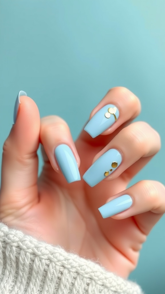 Light blue nails with gold foil details, showcasing a stylish manicure.