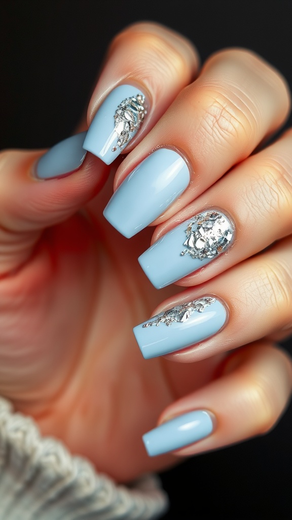 Nail art with light blue polish and silver foil accents