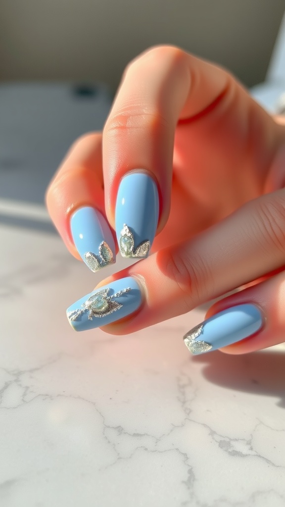 Light blue nails with silver foil accents, showcasing a chic and elegant design.