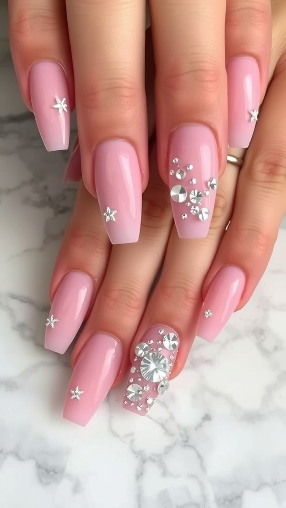 Light pink chrome nails with glitter accents and gems on a marble surface.