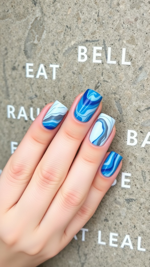A hand with blue marble effect nails against a textured background with letters.