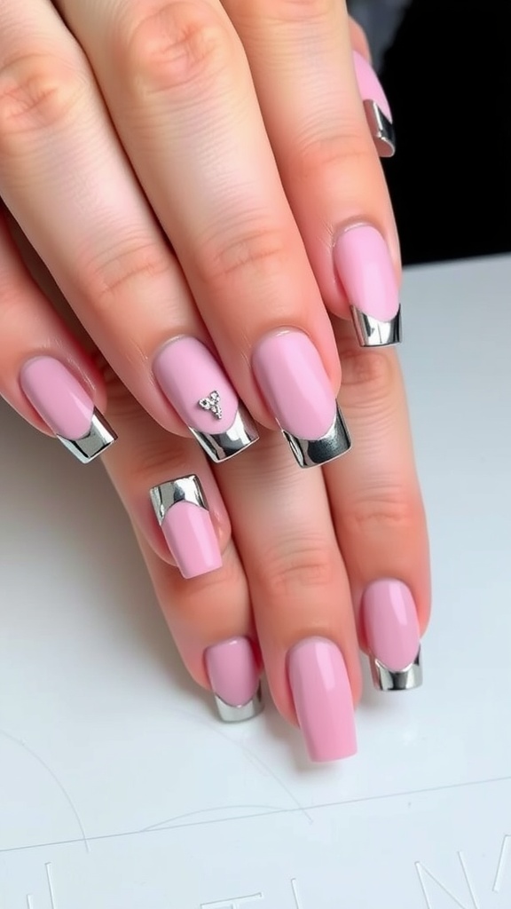 Nails with matte pink base and shiny chrome tips, featuring a small gem on one nail.