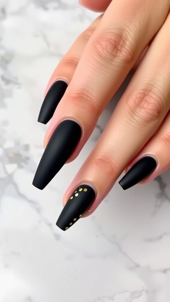 Stylish matte black coffin nails with gold foil accents.