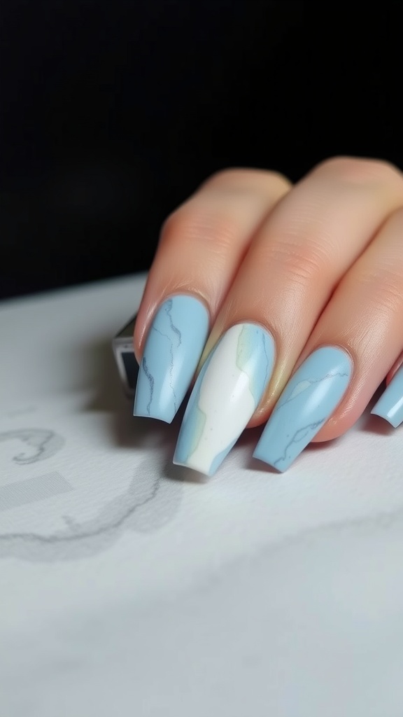 Matte finish light blue marble nails with swirls of white and subtle green accents.
