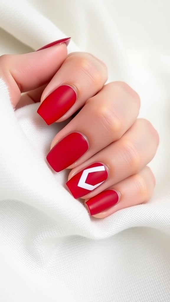 Matte red nails with a glossy white geometric design on a light background