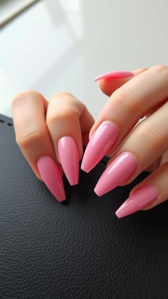 Close-up of hands with long pink chrome nails on a black surface
