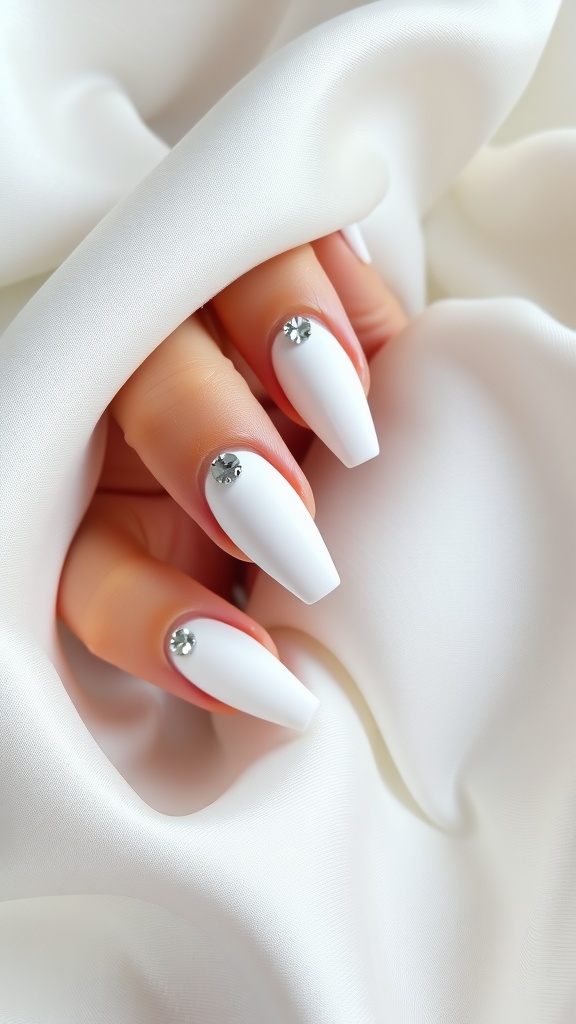 Matte white coffin nails with rhinestones on a silky white background