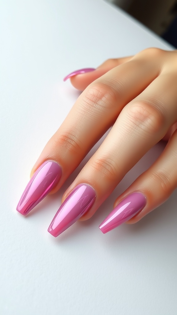 A close-up of a hand with pink chrome nails in a stiletto shape resting on a white surface.