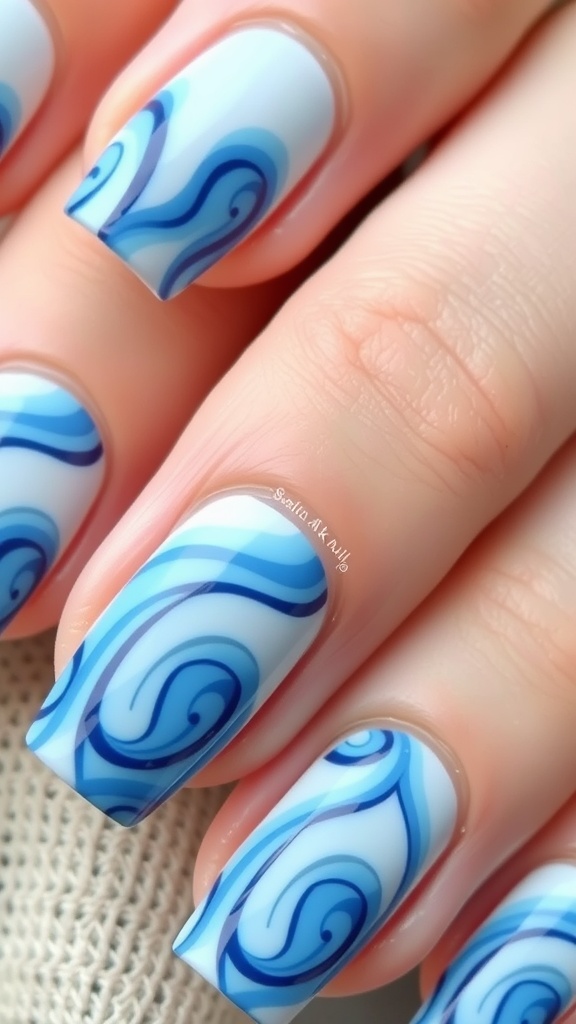 Nail design featuring light and dark blue ocean wave patterns