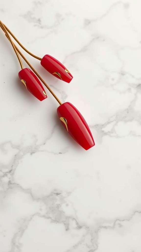 Close-up of red nails with gold foil details on a marble background.
