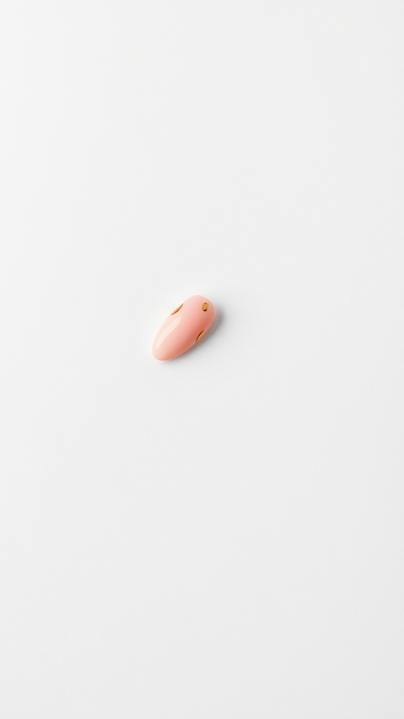 A soft pink almond-shaped nail with rose gold foil accents