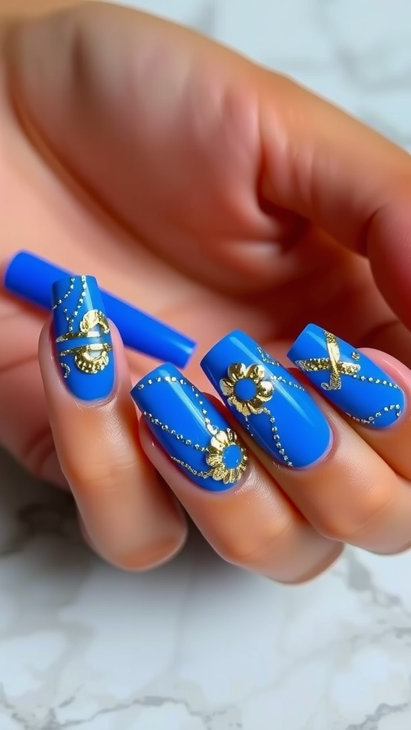Close-up of royal blue acrylic nails with gold foil accents